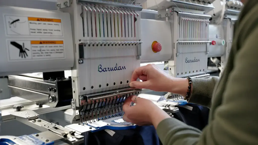 Tête de broderie industrielle Barudan en cours de fonctionnement, gros plan sur les fils