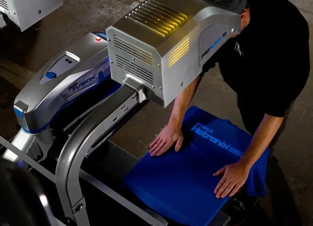 Presse à chaud pneumatique réalisant un transfert textile en atelier