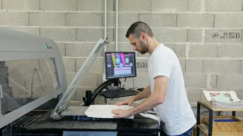 Opérateur conduisant une imprimante DTG (Direct To Garment) en atelier